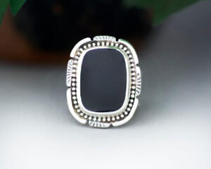 front close up, cushion black onyx gemstone bezel set bead wire and stamped cutout wire accent on tapered wide band